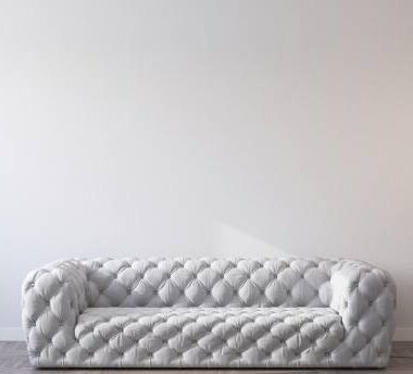 Modern sofa on empty wall background