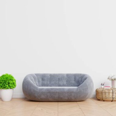 Potted plant by sofa against wall at home