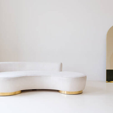 Modern minimalist interior with green velvet ottoman and gold accents