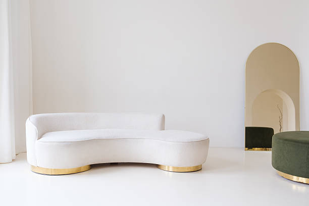 Modern minimalist interior with green velvet ottoman and gold accents